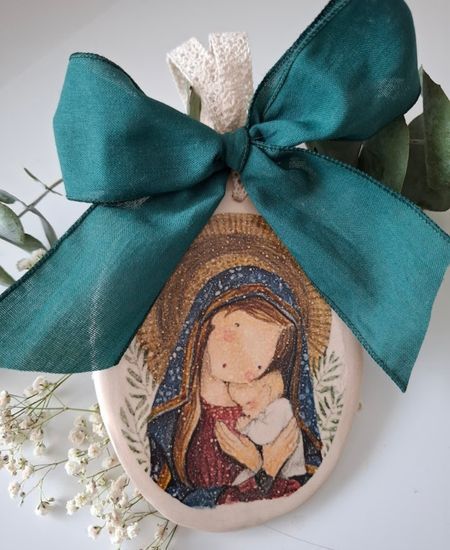 Medalla de cerámica con imagen de la Virgen María y el Niño Jesús, decorada con un lazo verde