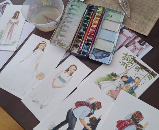 Mesa de trabajo con acuarelas y dibujos hechos a mano de escenas familiares y religiosas