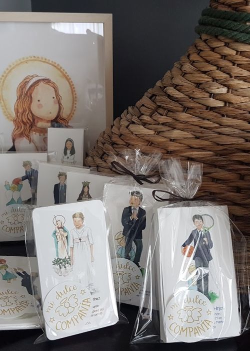 Variedad de recordatorios de Primera Comunión personalizados con ilustraciones de niños y niñas en trajes de comunión, empaquetados en bolsitas transparentes.