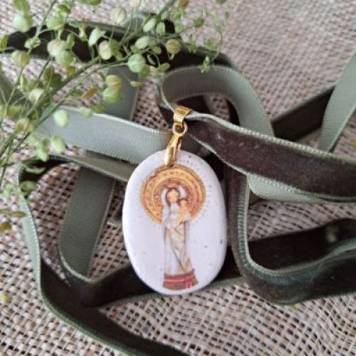 Medalla con ilustración de la Virgen con Niño, sobre cinta de terciopelo verde.