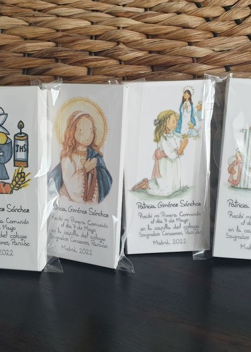 Recordatorios de Primera Comunión personalizados con ilustraciones religiosas y de comunión, cada uno con el nombre de la niña y fecha del evento.